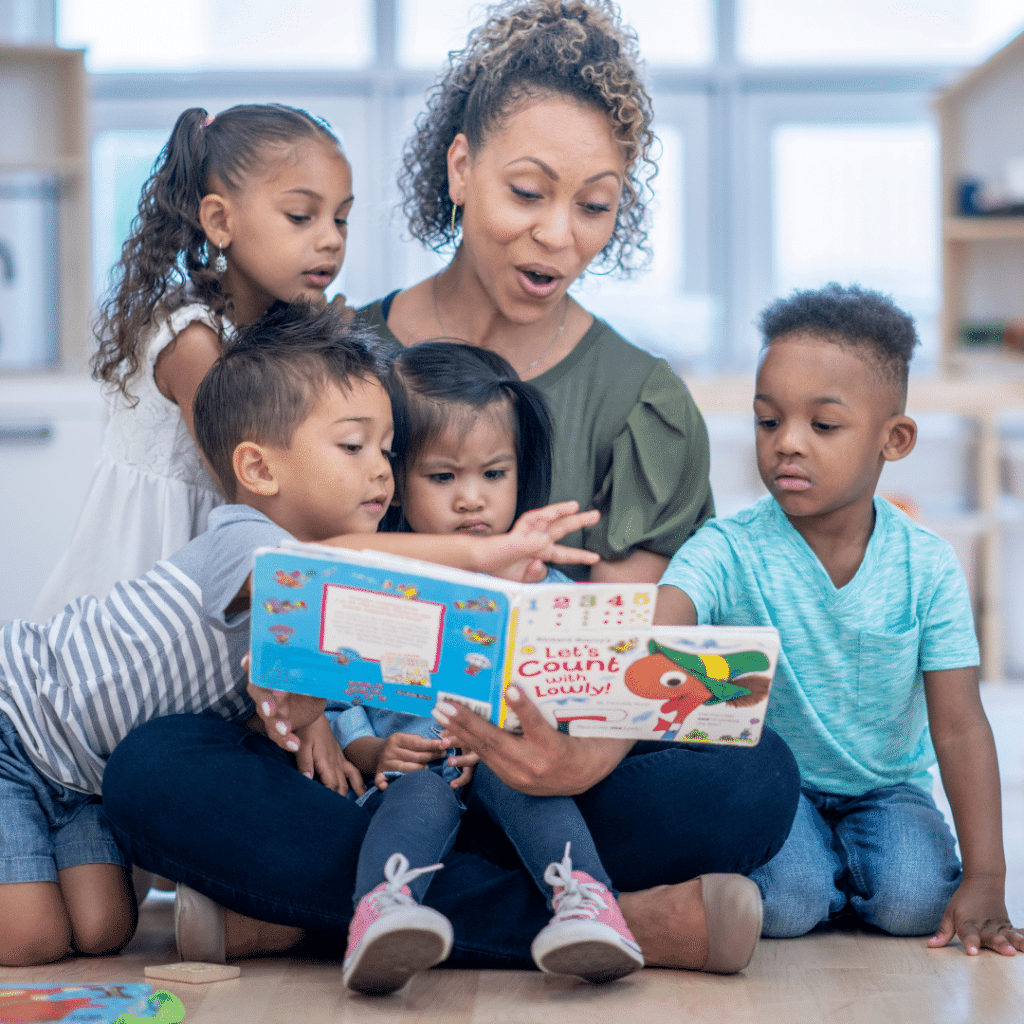 A woman is reading a book to a group of children.