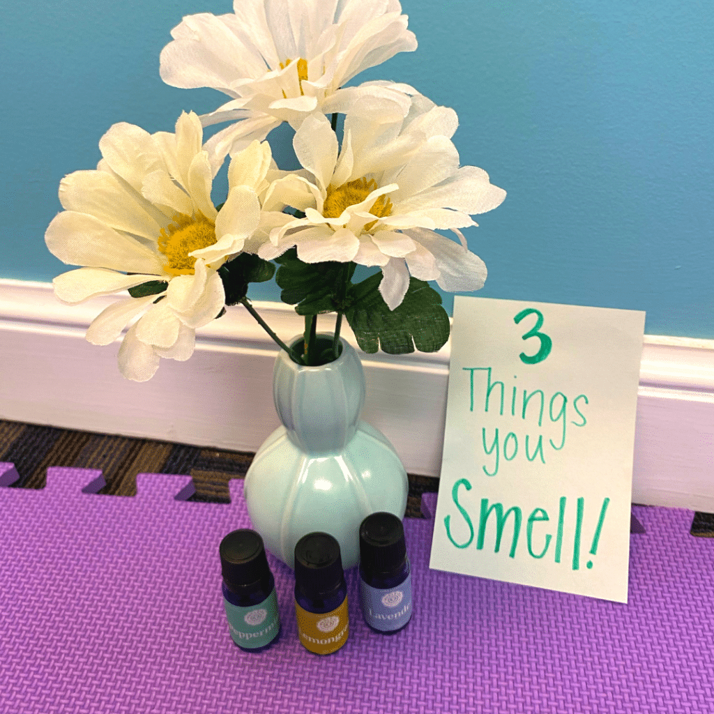 A sign that says 3 things you smell next to a vase of flowers