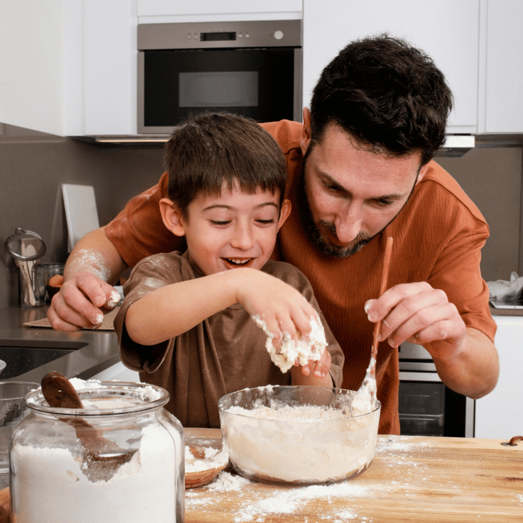 A man and a boy are mixing ingredients in a bowl in a kitchen.