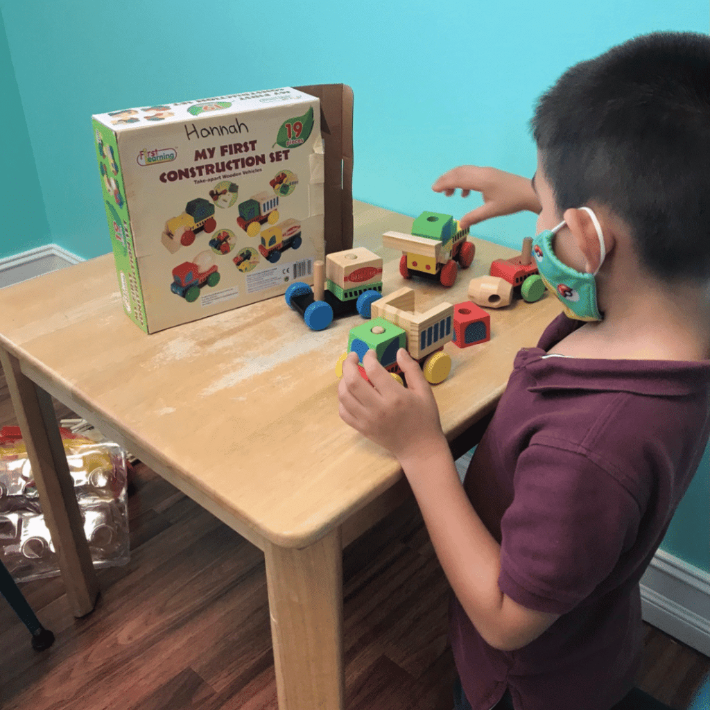 A young boy is playing with a wooden construction set