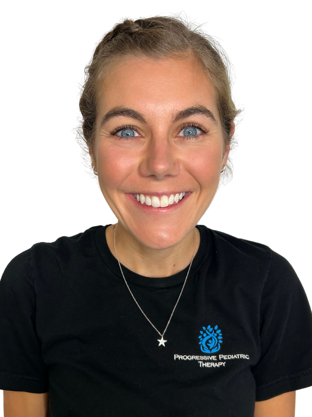 A woman wearing a black shirt and a necklace is smiling.