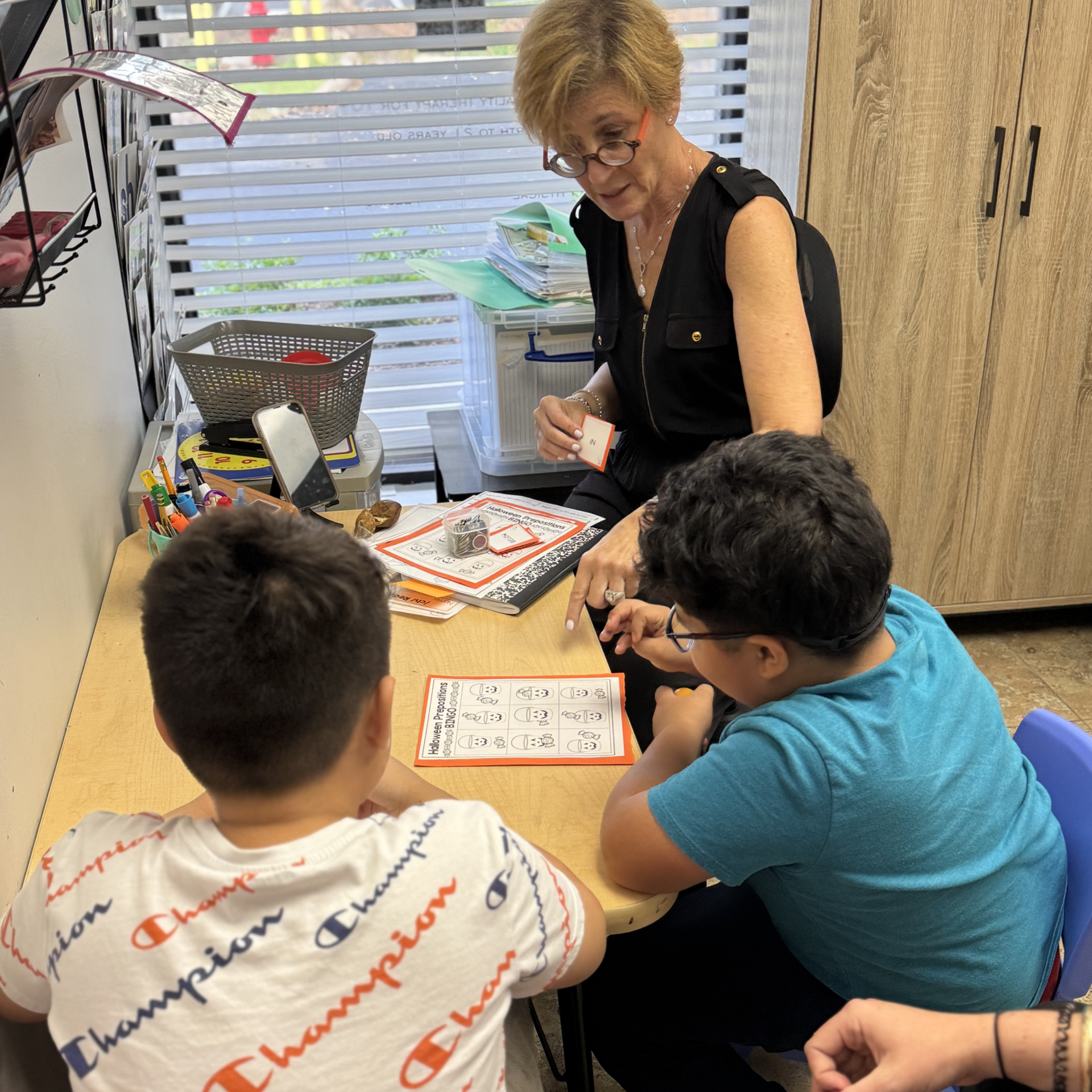 A woman and child are sitting at a table with a rainbow cake on a plate