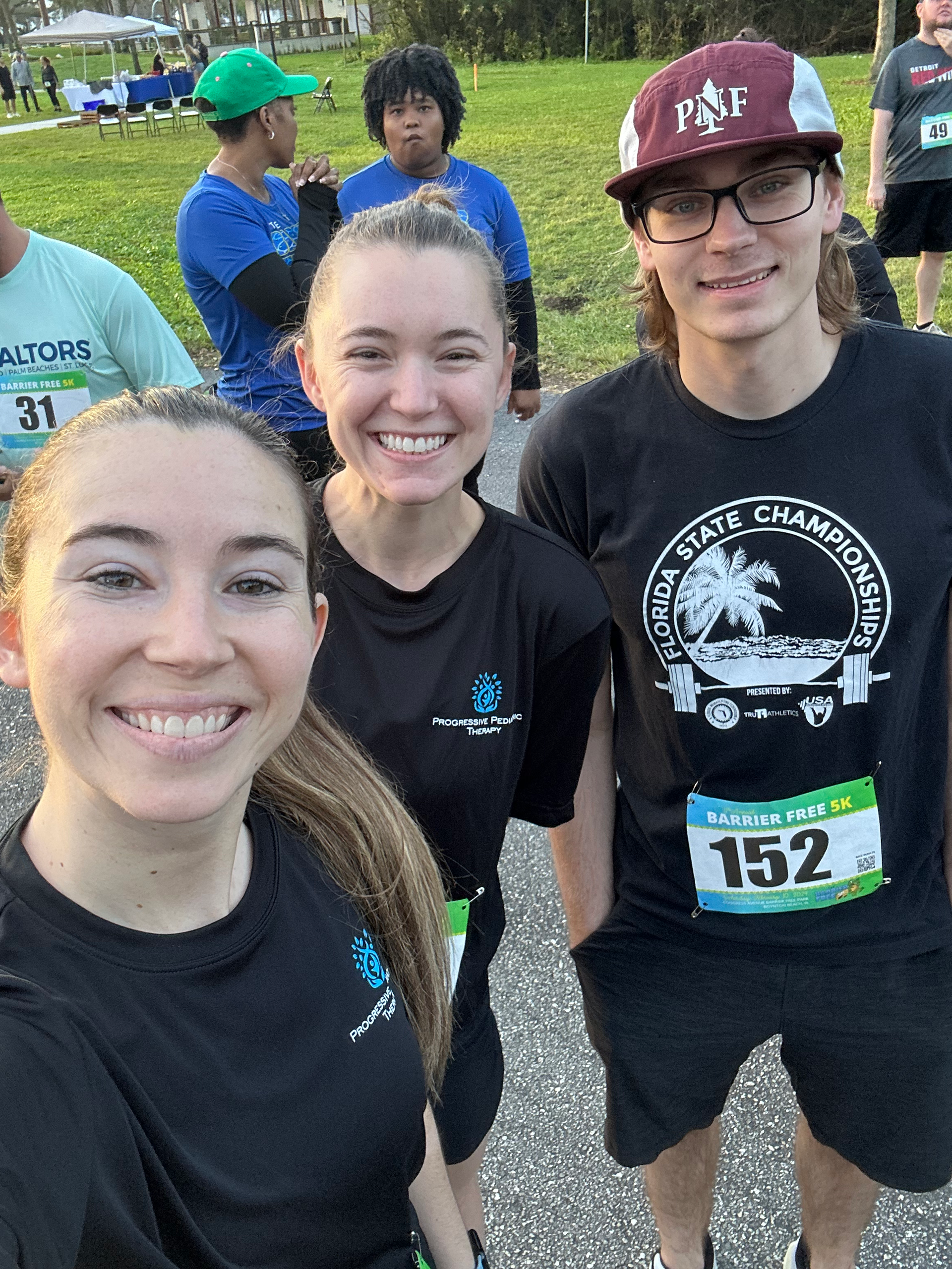 A group of people are posing for a picture in a park.