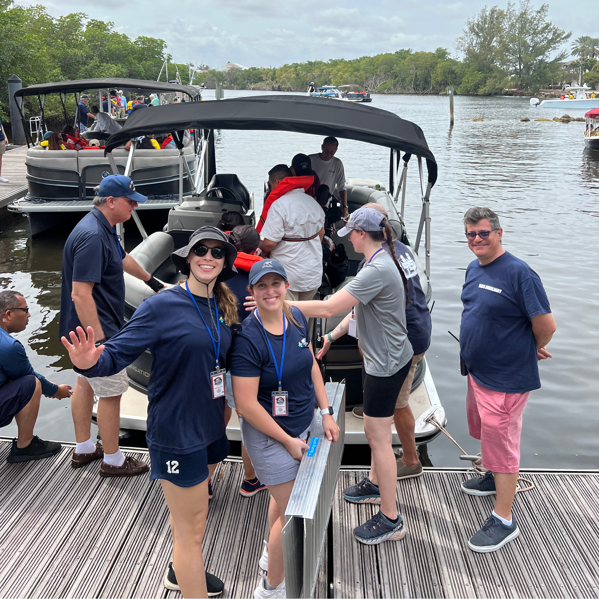 A group of people standing on a dock next to a boat