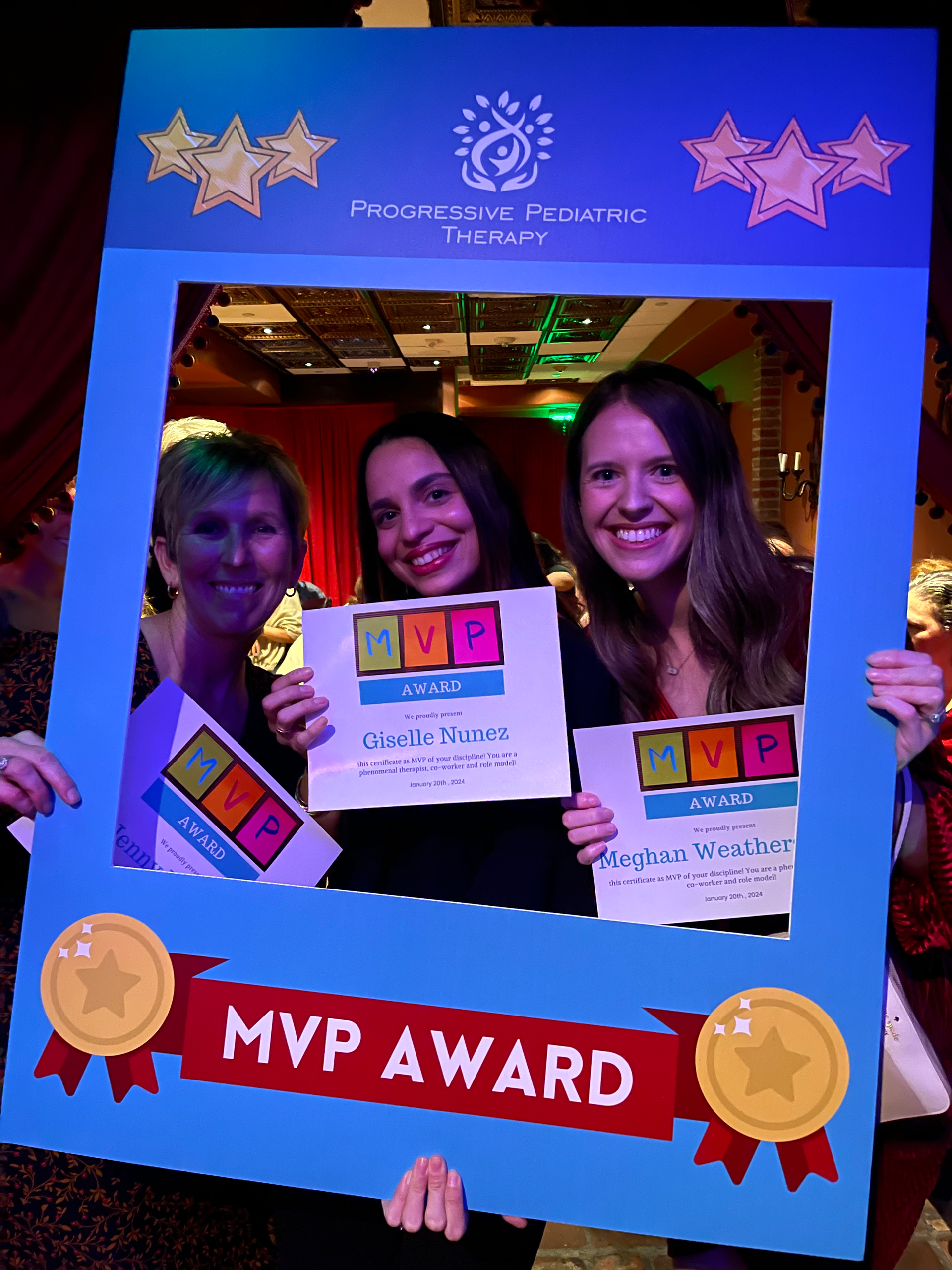 Three women are posing for a picture in a mvp award frame