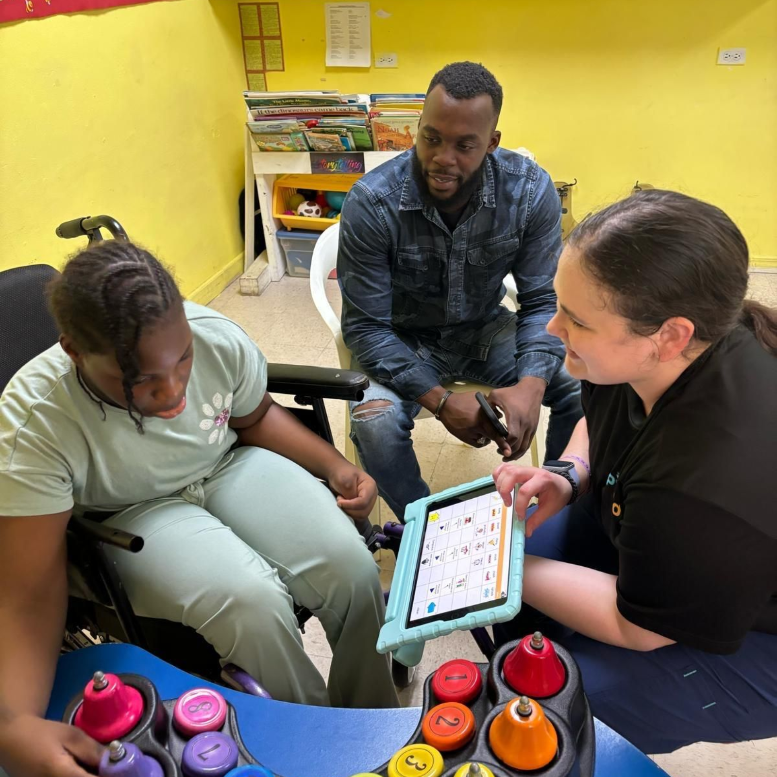 A woman is kneeling next to a child sitting on a swing.