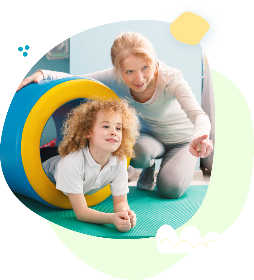 A woman is kneeling next to a little girl laying on the floor.