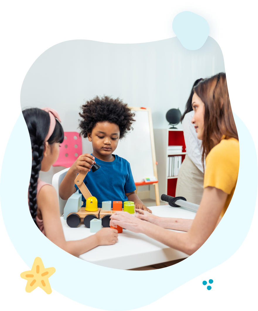 A group of children are sitting at a table playing with toys.