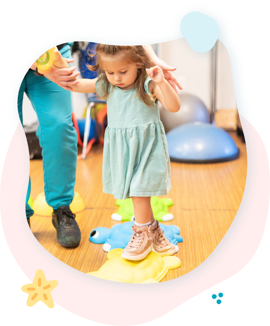 A little girl is standing on a toy frog.