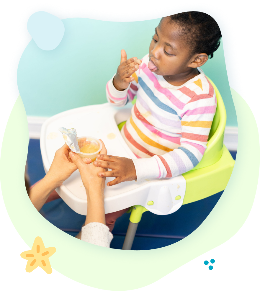 A little girl is sitting in a high chair eating food.