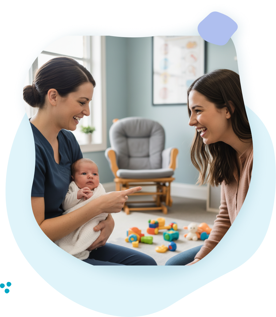Woman in scrubs points at a newborn held by another woman. A third woman smiles at them. Nursery setting.