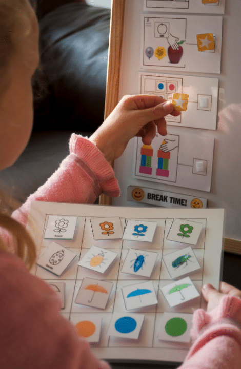 A little girl is playing with a board that says break time