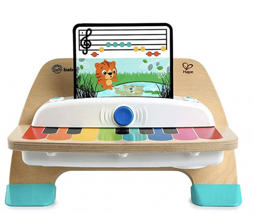 A wooden toy piano with a screen on top of it.