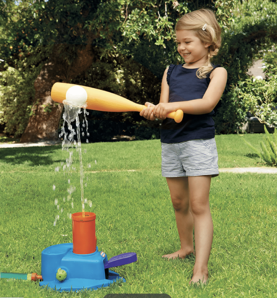 A little girl is playing with a water baseball bat