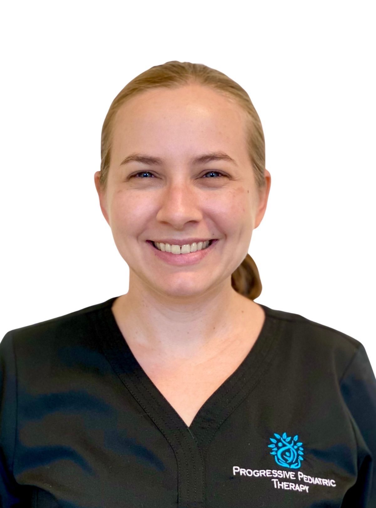A woman in a black scrub top is smiling for the camera.