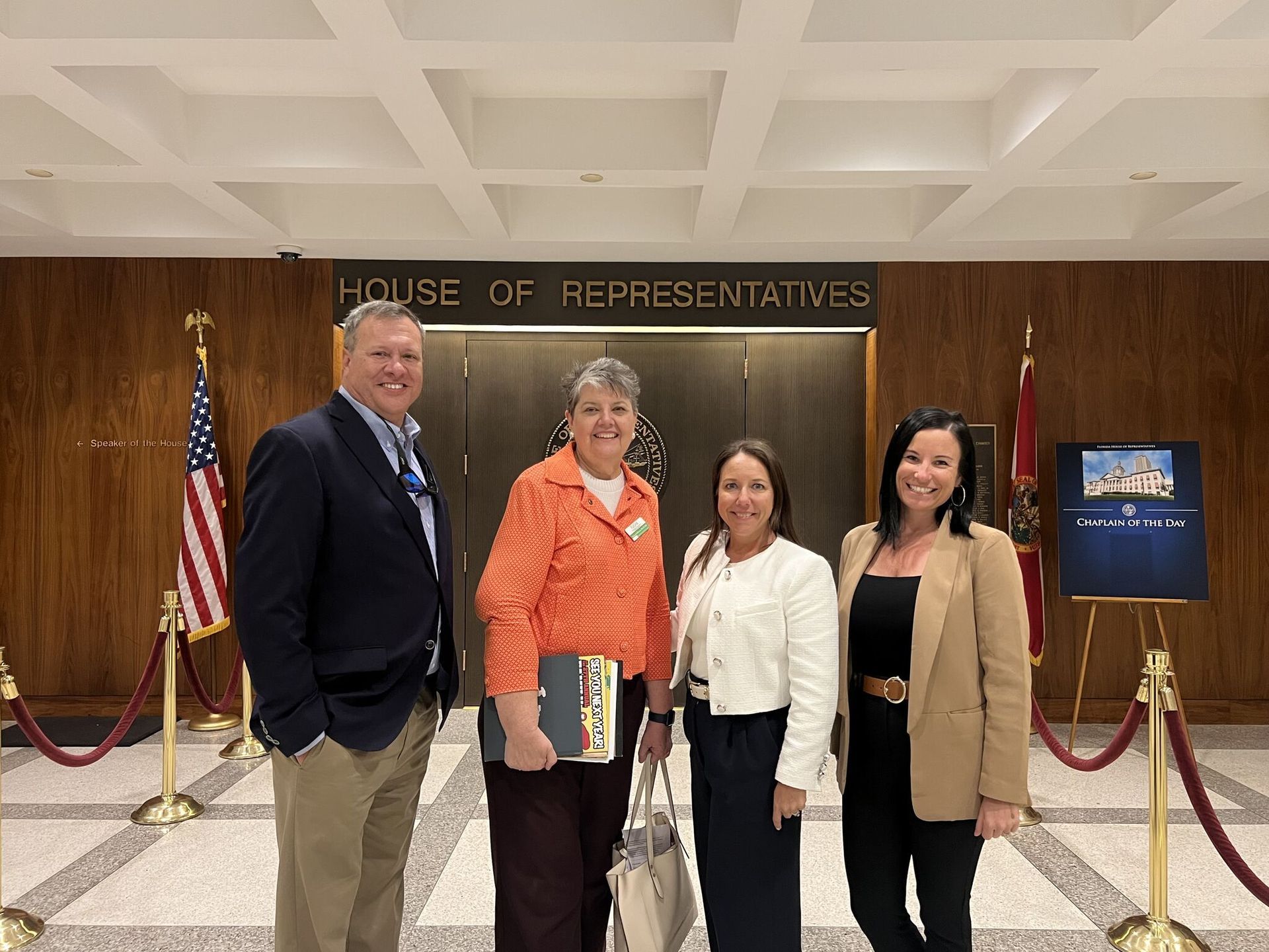 Four people pose in front of a 