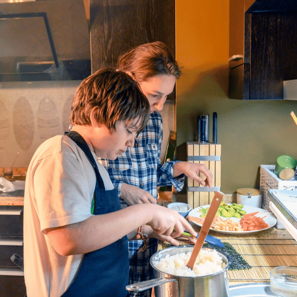 A woman and a boy are preparing food in a kitchen.