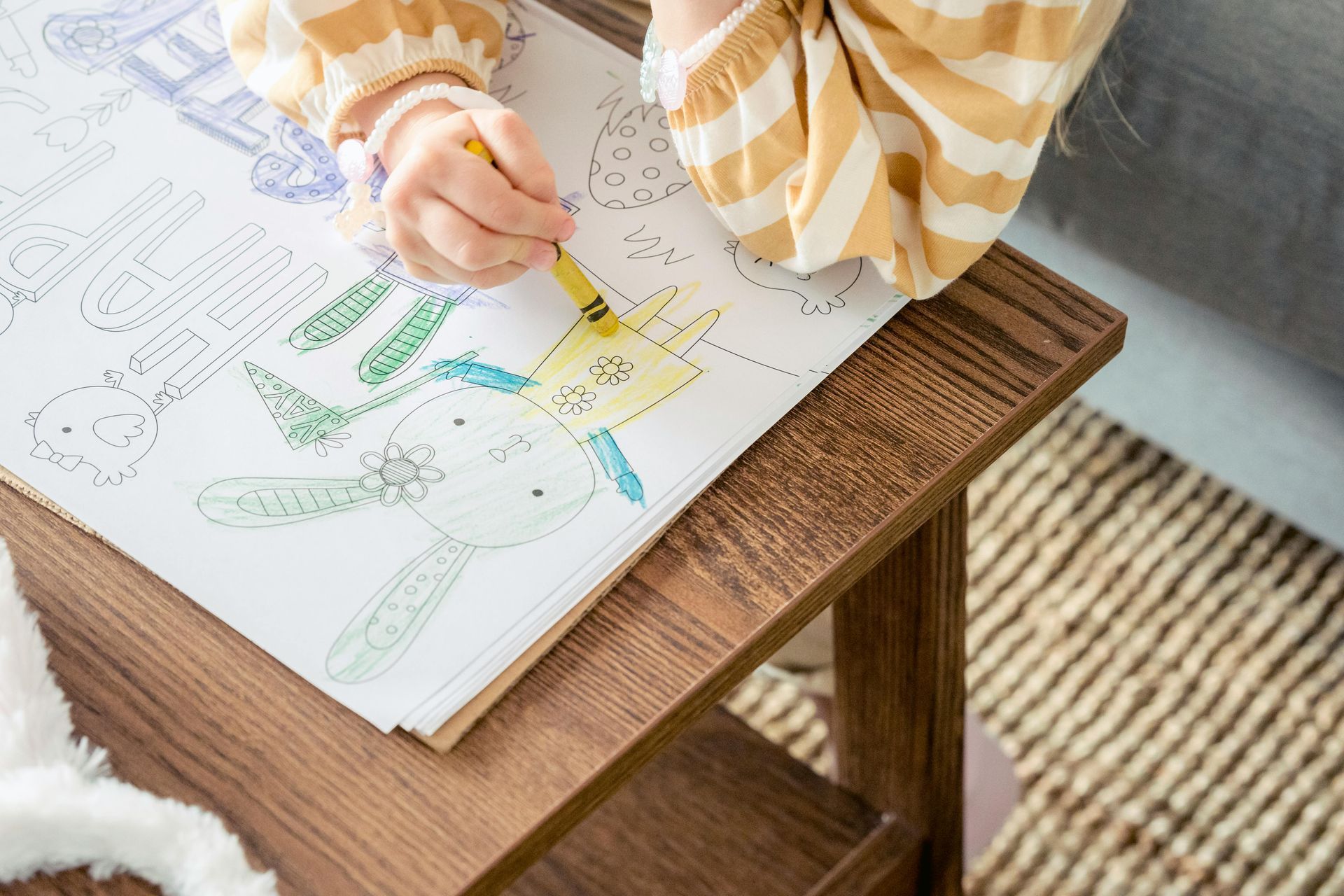 A child is sitting at a table drawing with a marker.