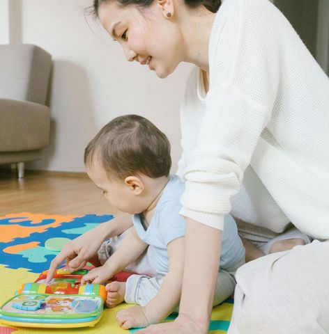 A woman and child are playing with blocks on the floor