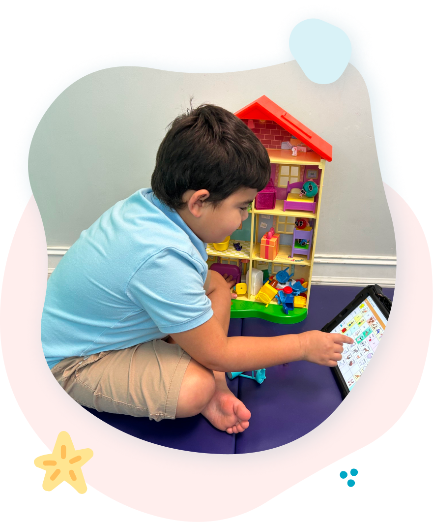A young boy is sitting on the floor playing with a tablet.
