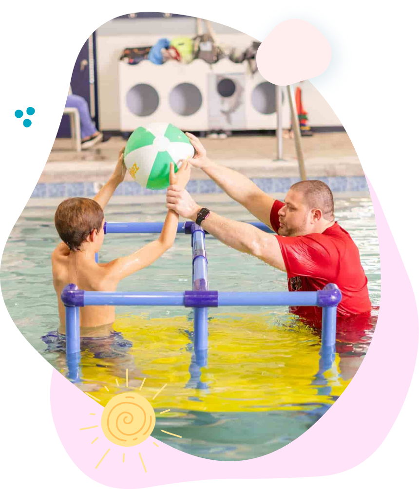 A man and a boy are playing with a ball in a swimming pool.