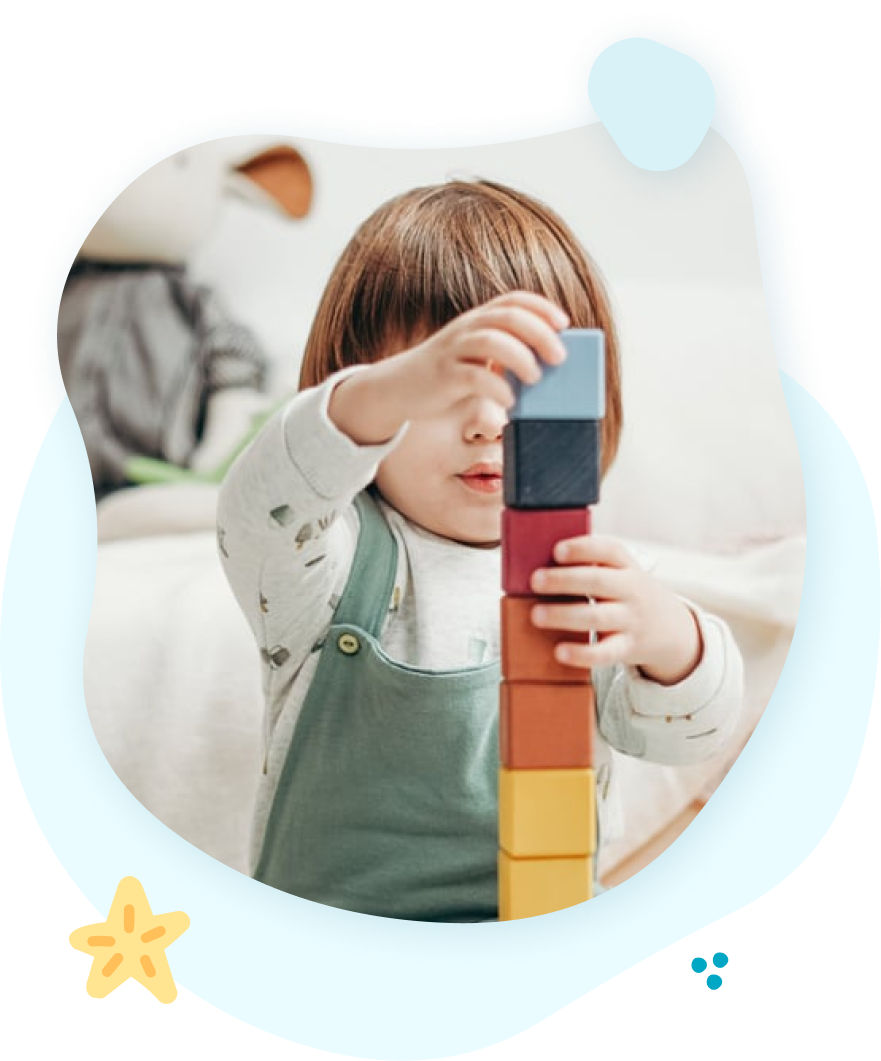 A little girl is playing with blocks on a couch.