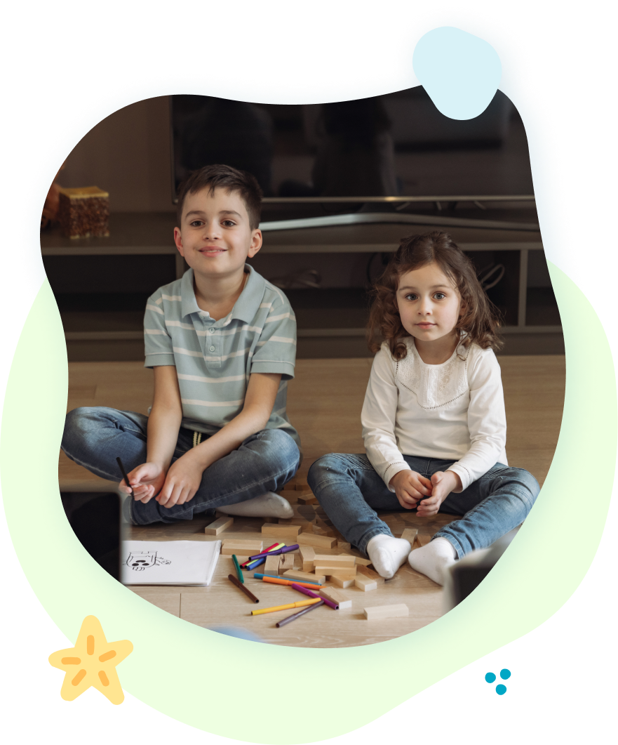 A boy and a girl are sitting on the floor playing with toys.