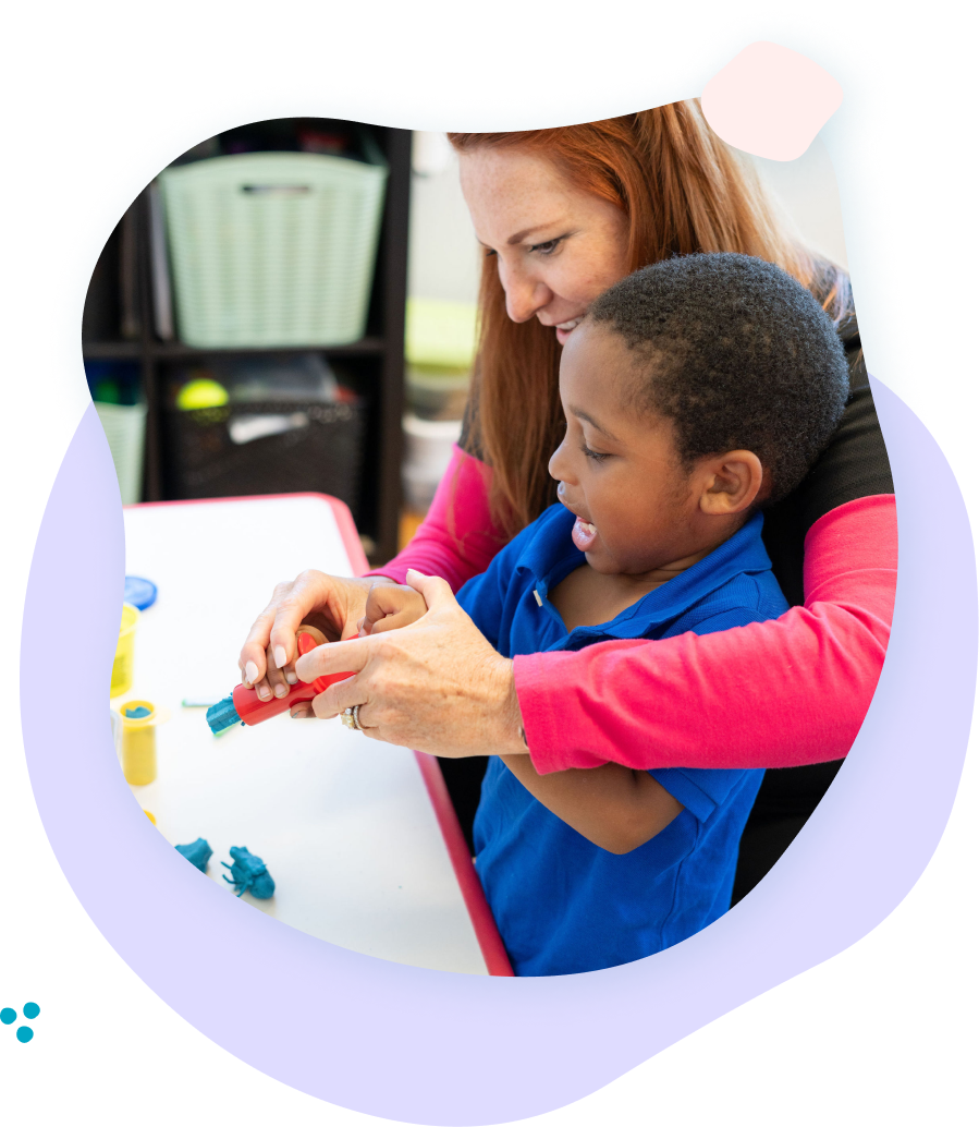 A woman is teaching a young boy how to use a screwdriver.