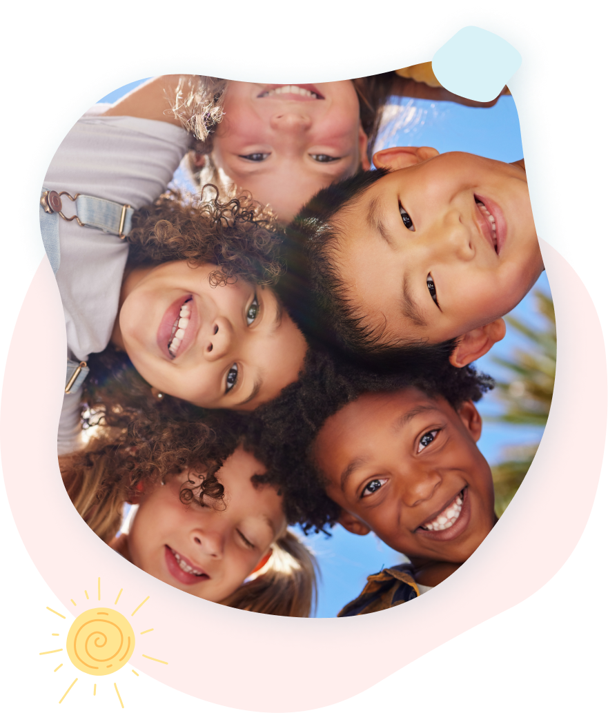 A group of children are standing in a circle and smiling at the camera.