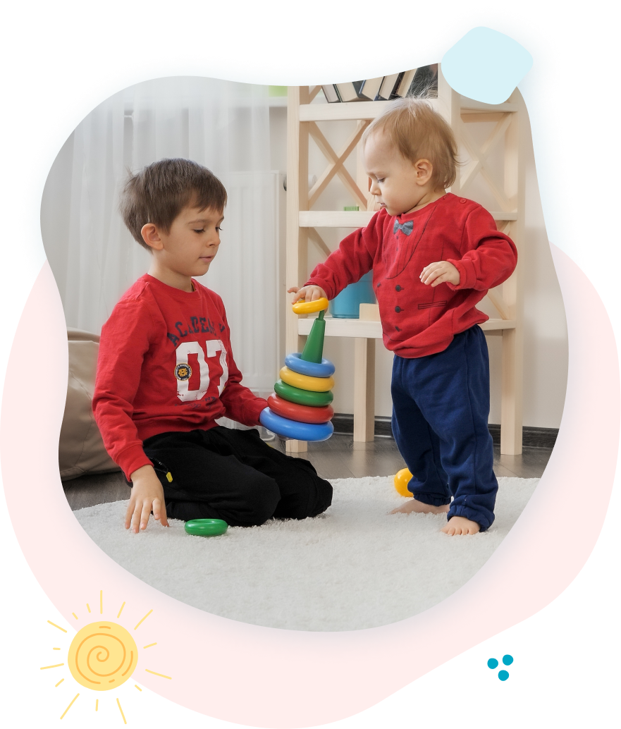 Two young boys are playing with toys on the floor.