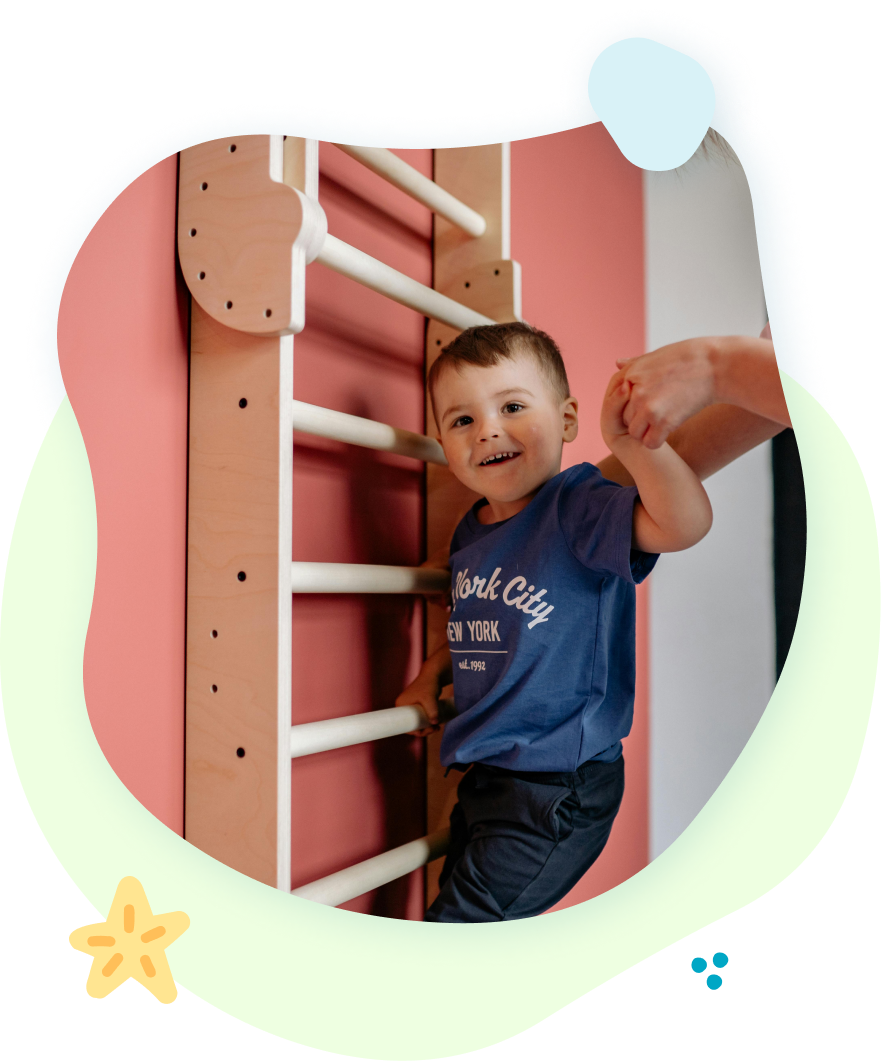 A child 's feet are standing on a green roller and a yellow ball.