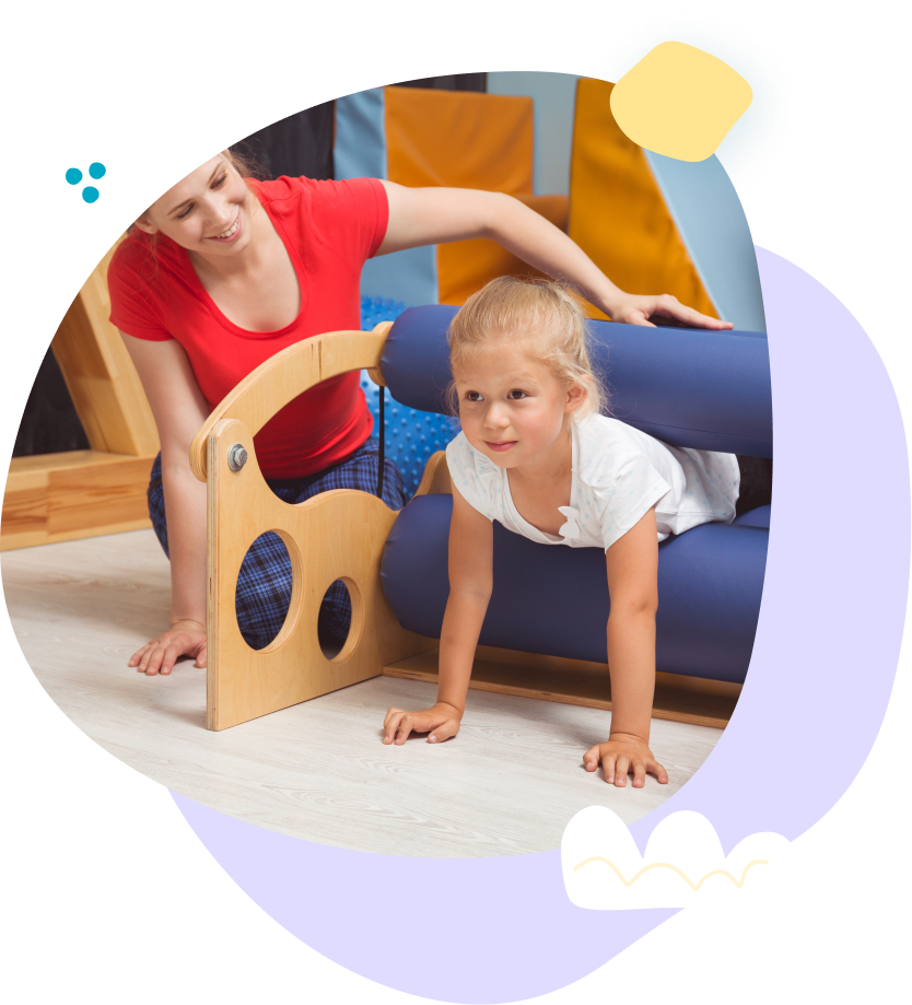 A woman is helping a little girl crawl on the floor.