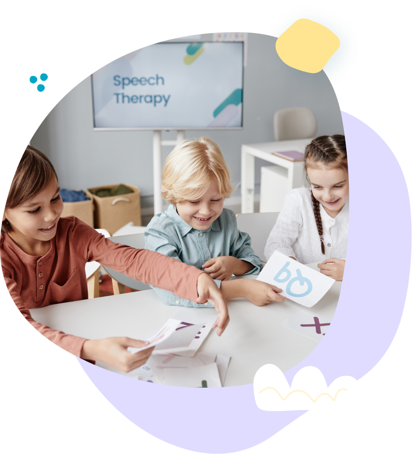 A group of children are sitting at a table in front of a screen that says speech therapy.