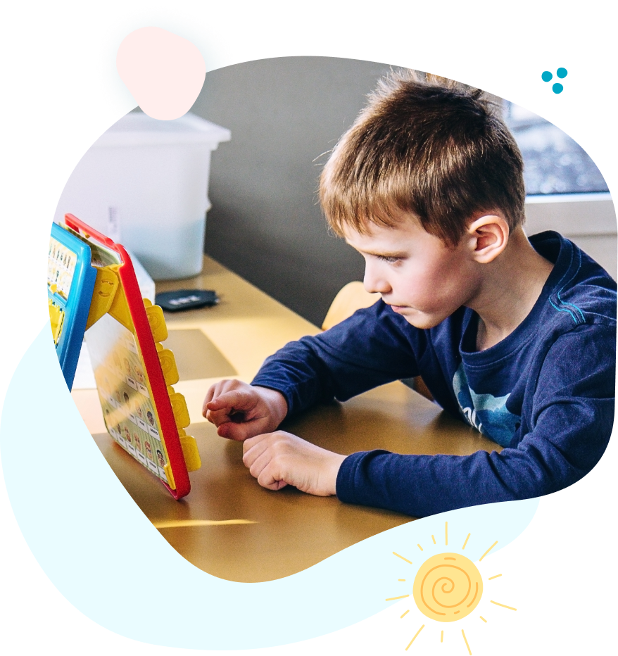 A young boy is sitting at a table playing with a toy.