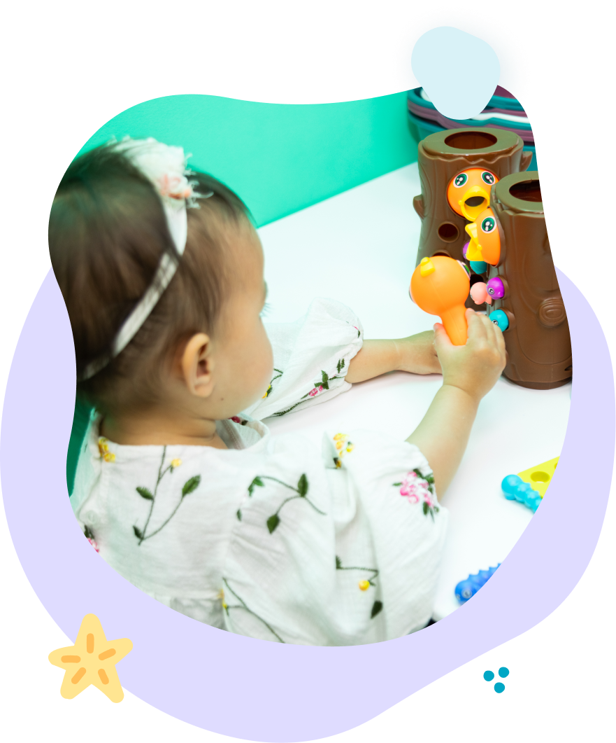 A little girl is playing with a toy on a table.