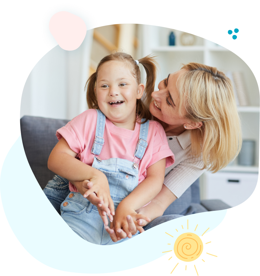 Therapist and child with down syndrome laughing together.