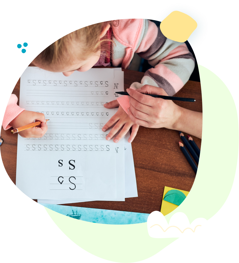 A little girl is writing the letter s on a piece of paper
