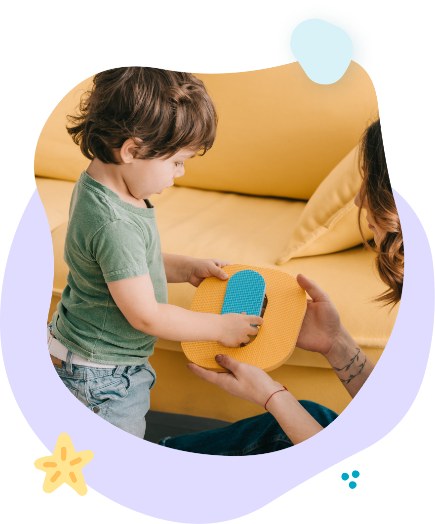 A little boy is playing with a sponge on a yellow couch.