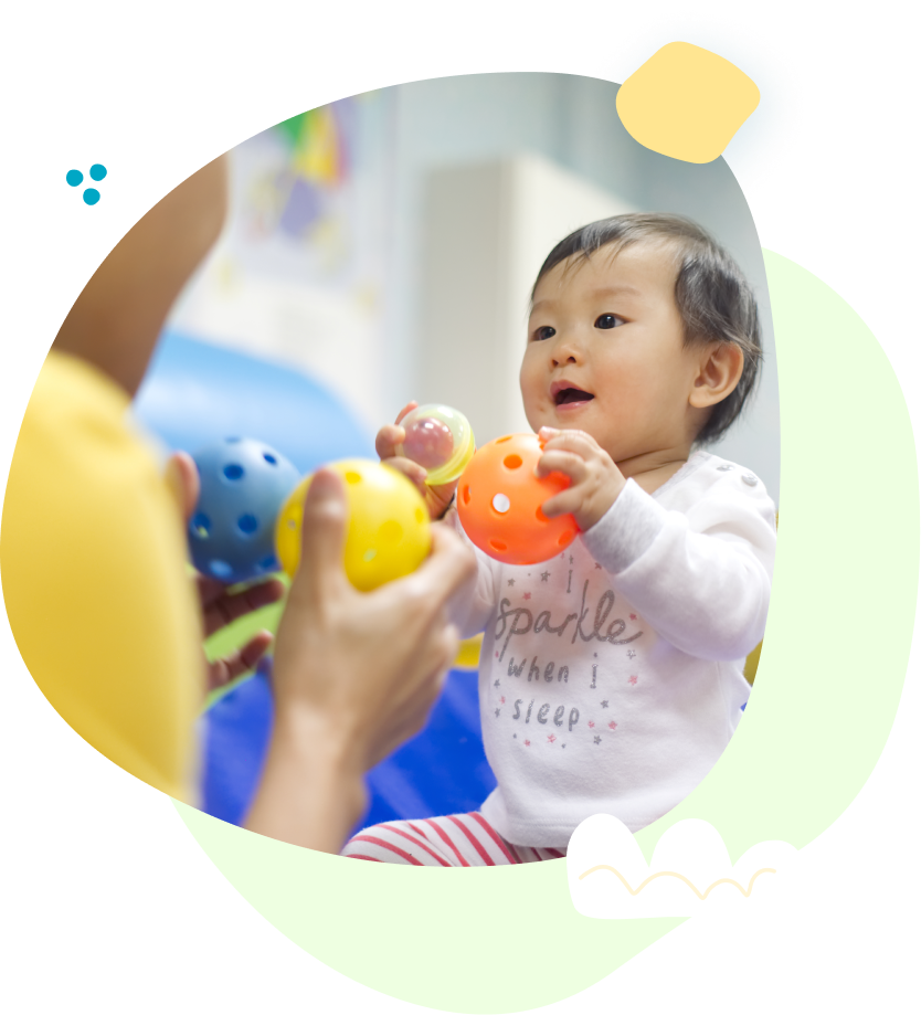 A baby is playing with balls in a room.