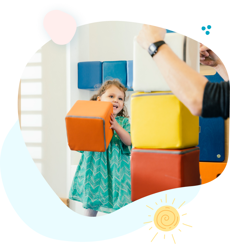A little girl is playing with blocks in a room.