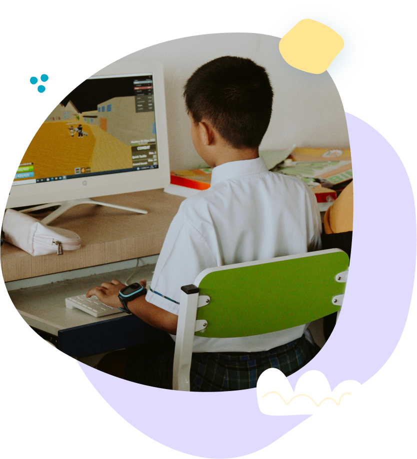 Two children in pink shirts, assisted by adults, use walkers in a therapy room.