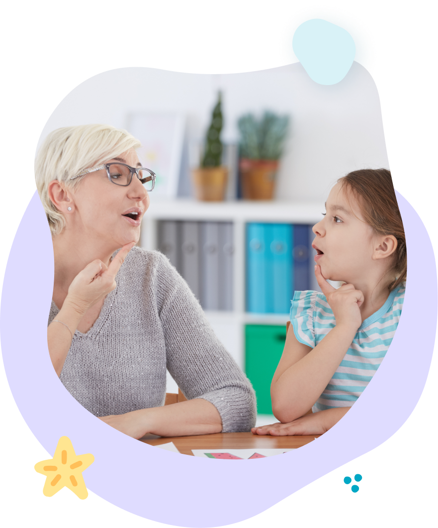 A woman and a little girl are sitting at a table talking to each other.