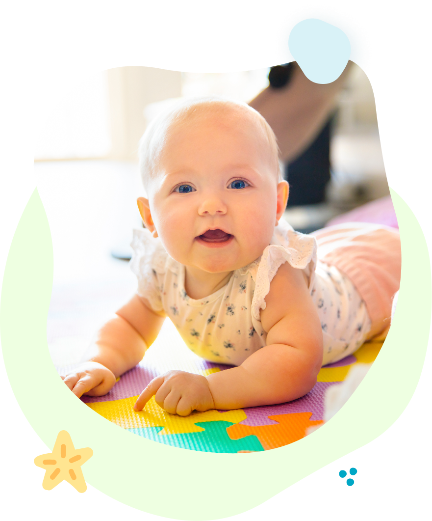 A baby is laying on its stomach on a puzzle mat.
