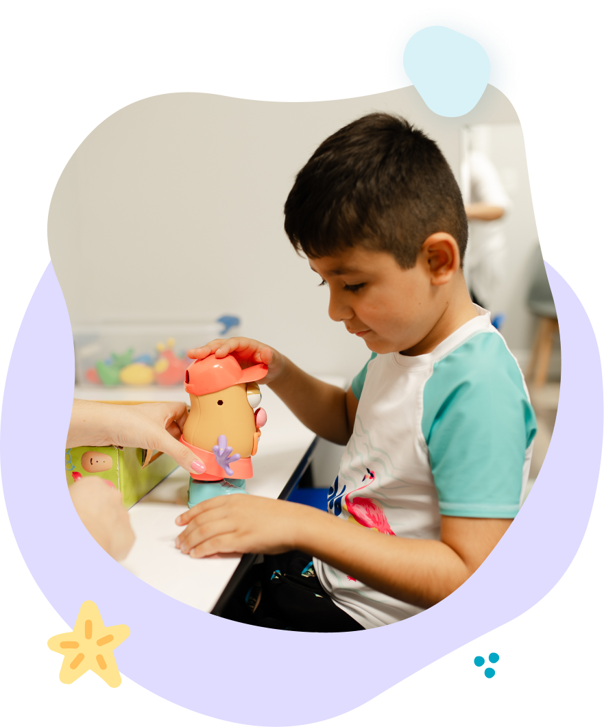 Boy playing with a toy at a table.