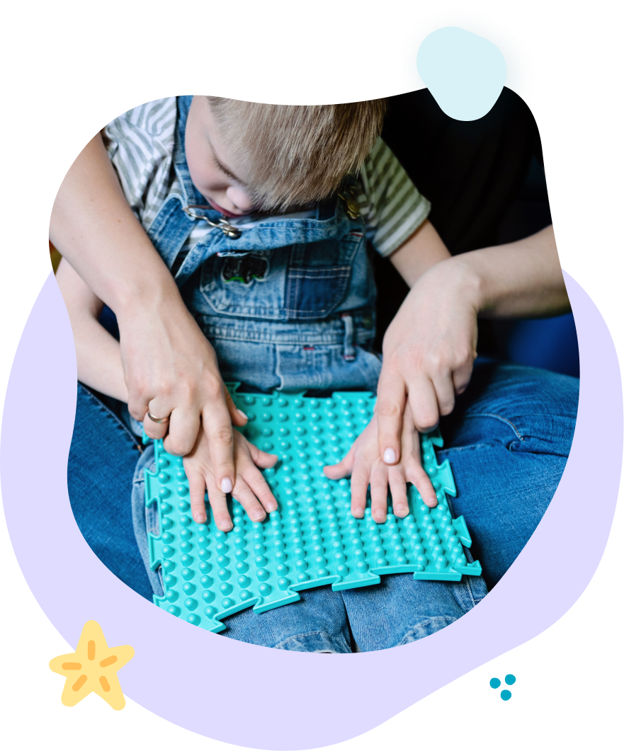 A little boy is sitting on a couch playing with a puzzle mat.