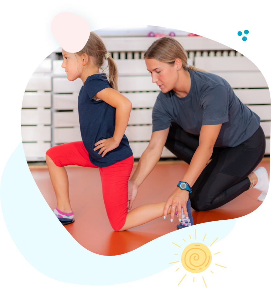 A woman is helping a little girl stretch her legs.