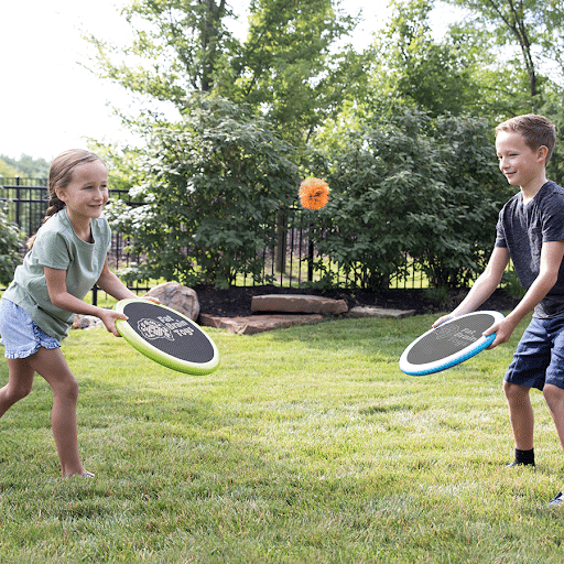 A boy and a girl are playing frisbee in the grass.