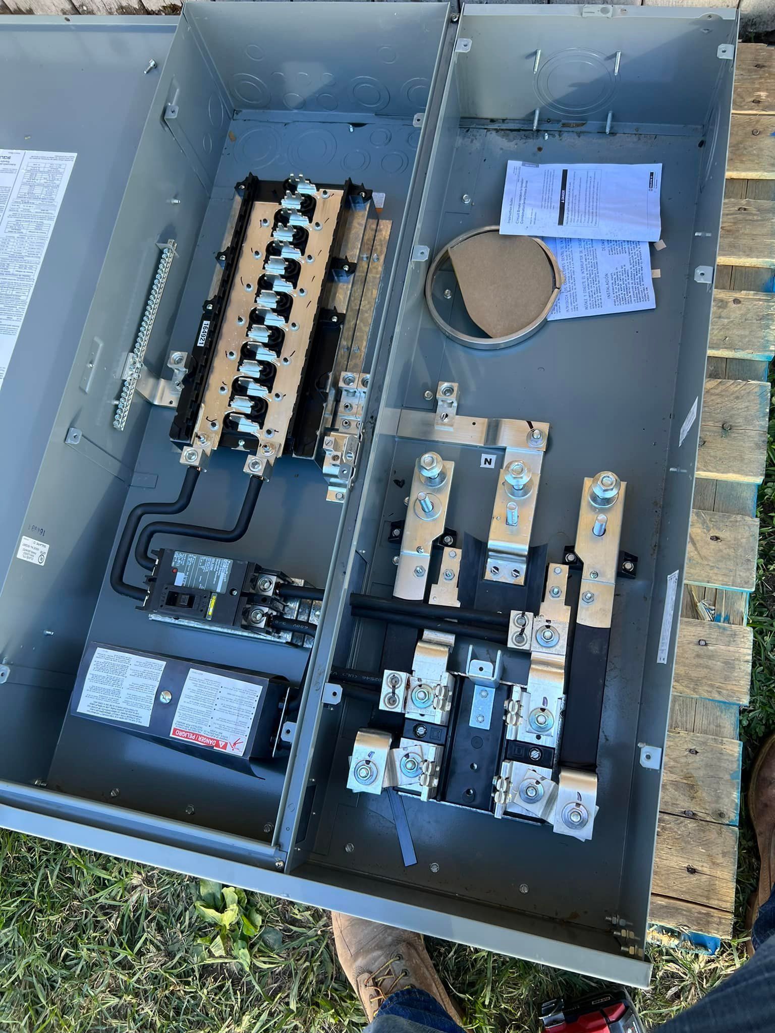 A box filled with electrical equipment is sitting on top of a wooden table.