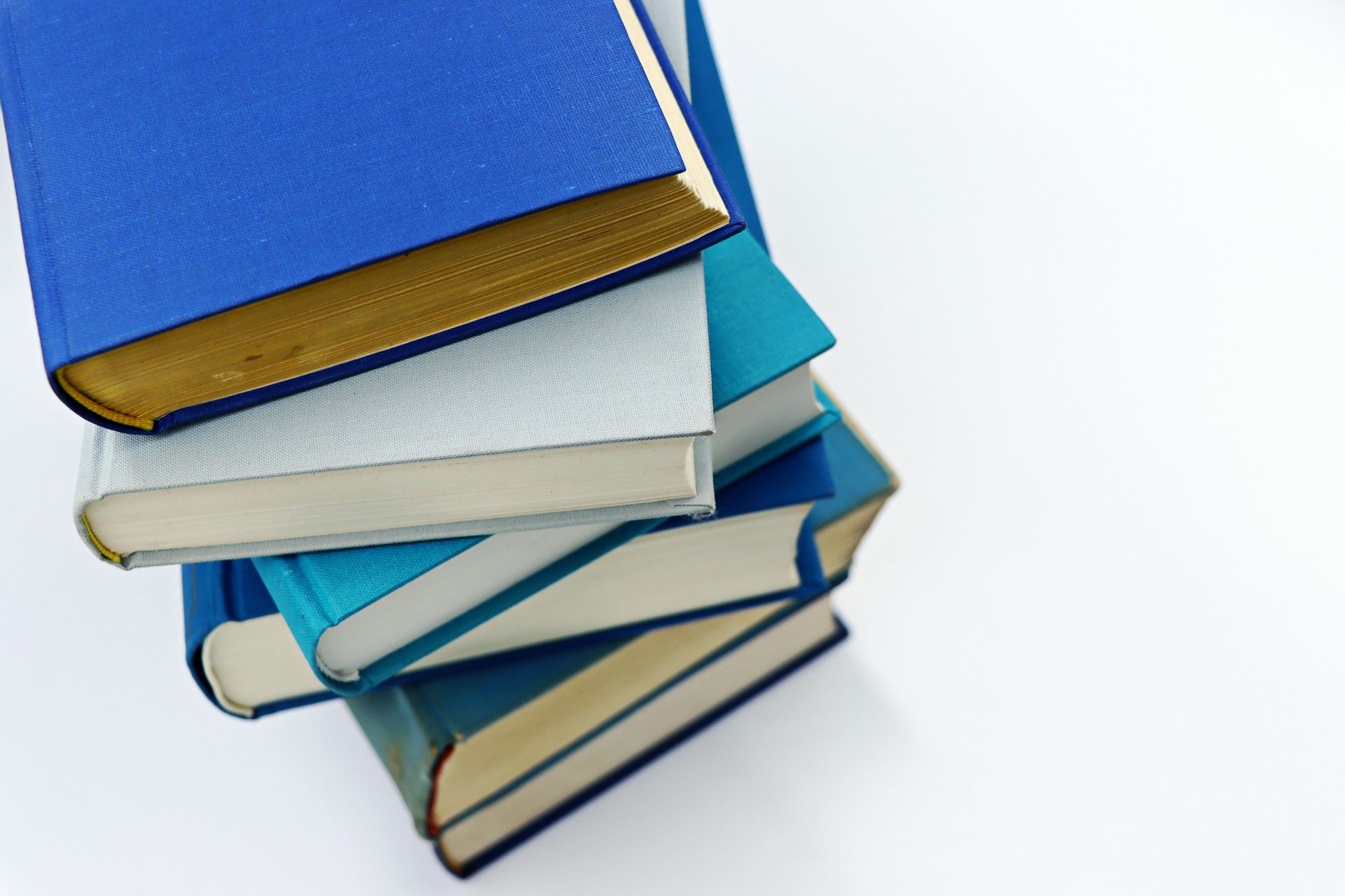 A stack of five books with blue and white covers arranged at different angles on a white background.