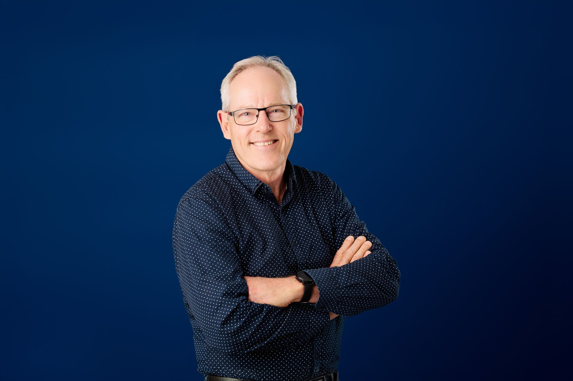 Sydney corporate headshot a man is smiling and wearing a blue and shirt.